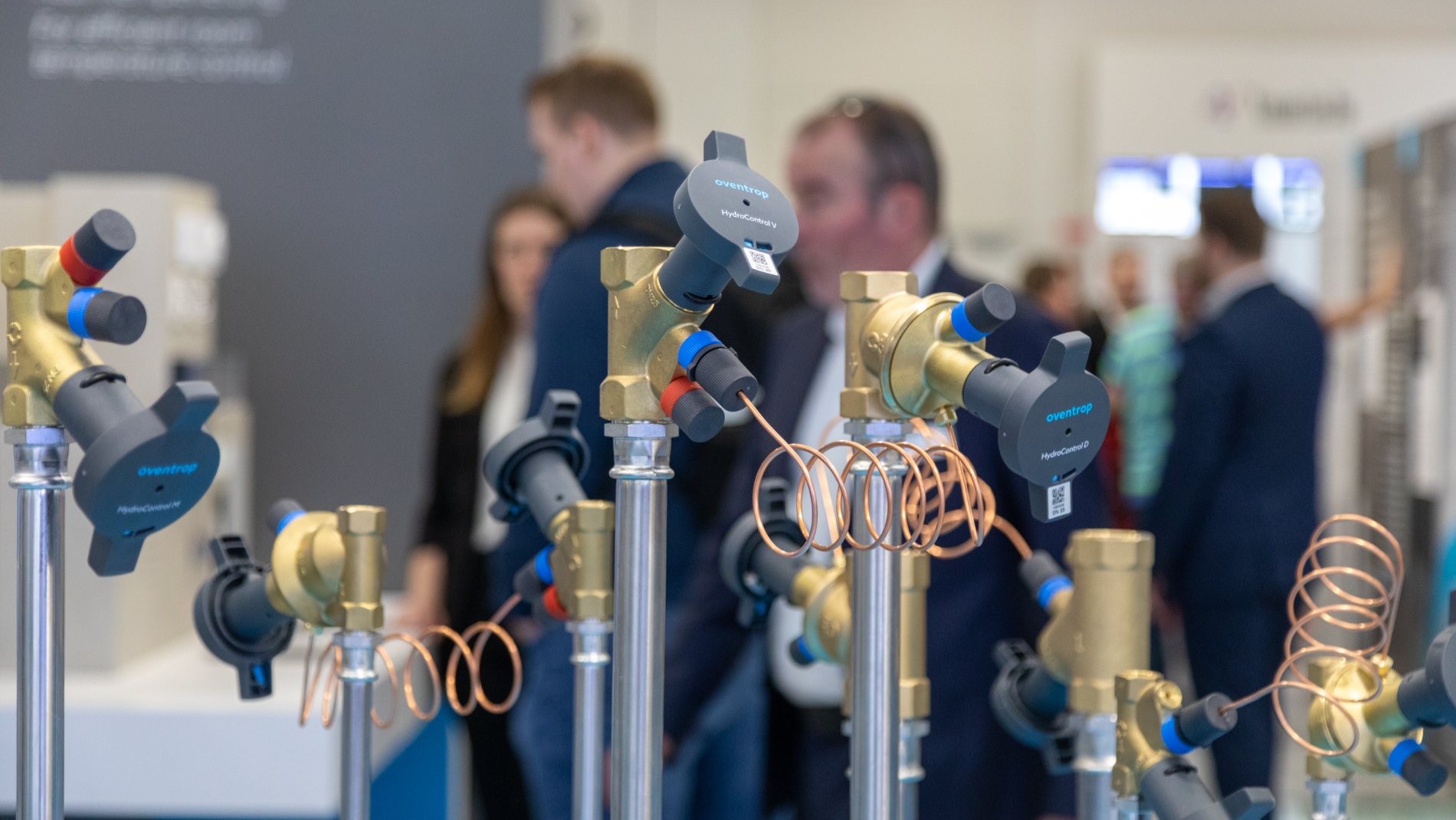 Trade fair visitors stand in front of components for heat generators