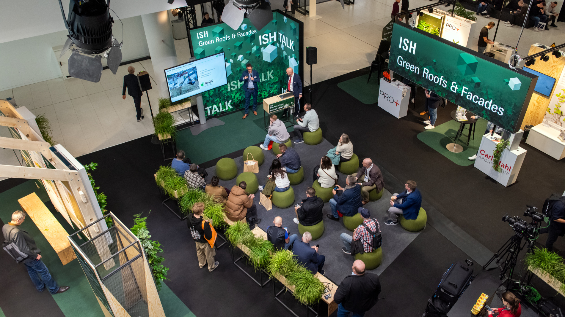 The audience is seated in front of a stage and listening to a talk.