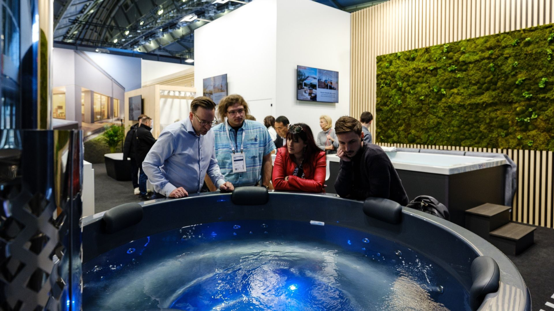 Messebesucher stehen an einem runden Indoor-Pool