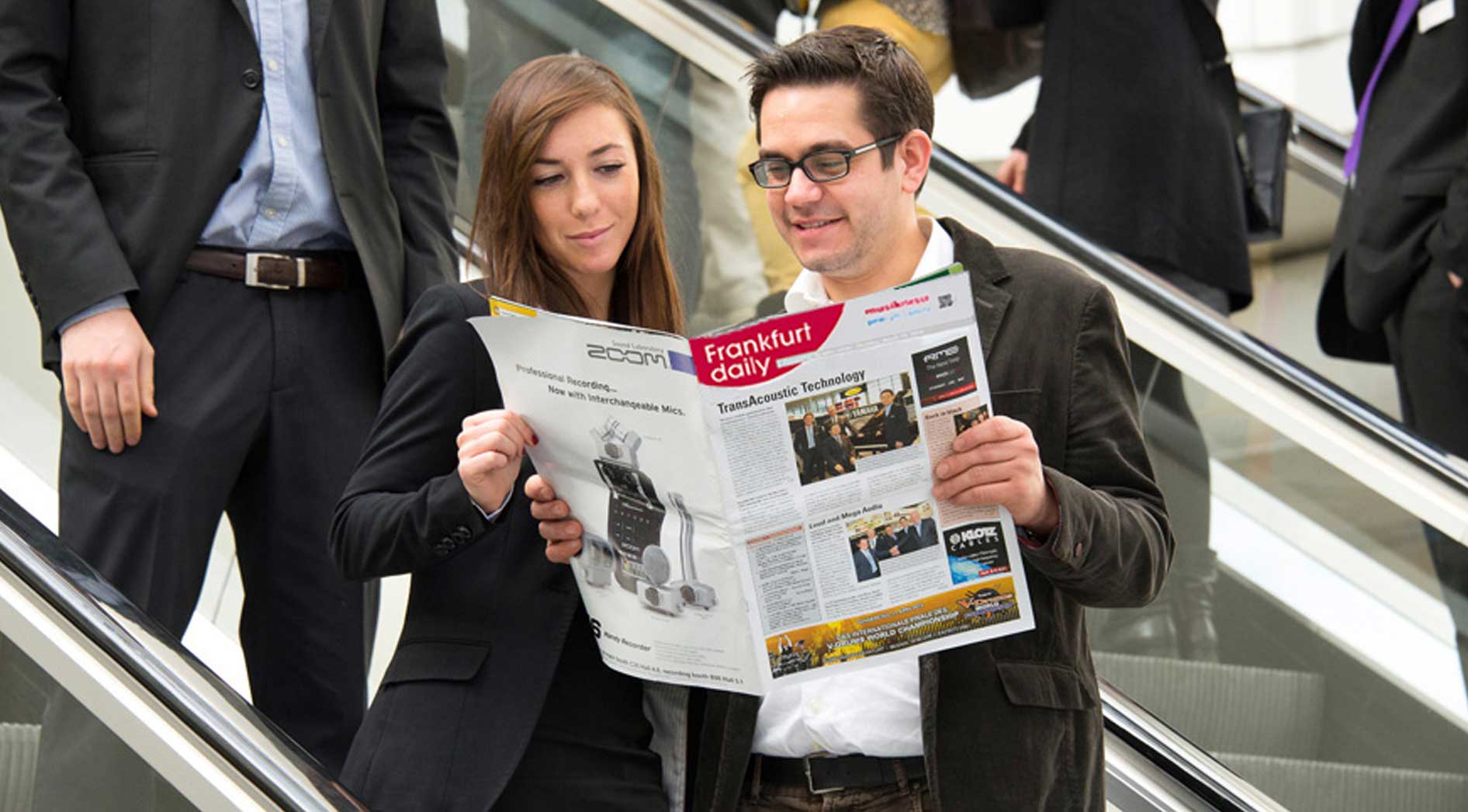 2 Personen lesen das Messemagazin Frankfurt Daily